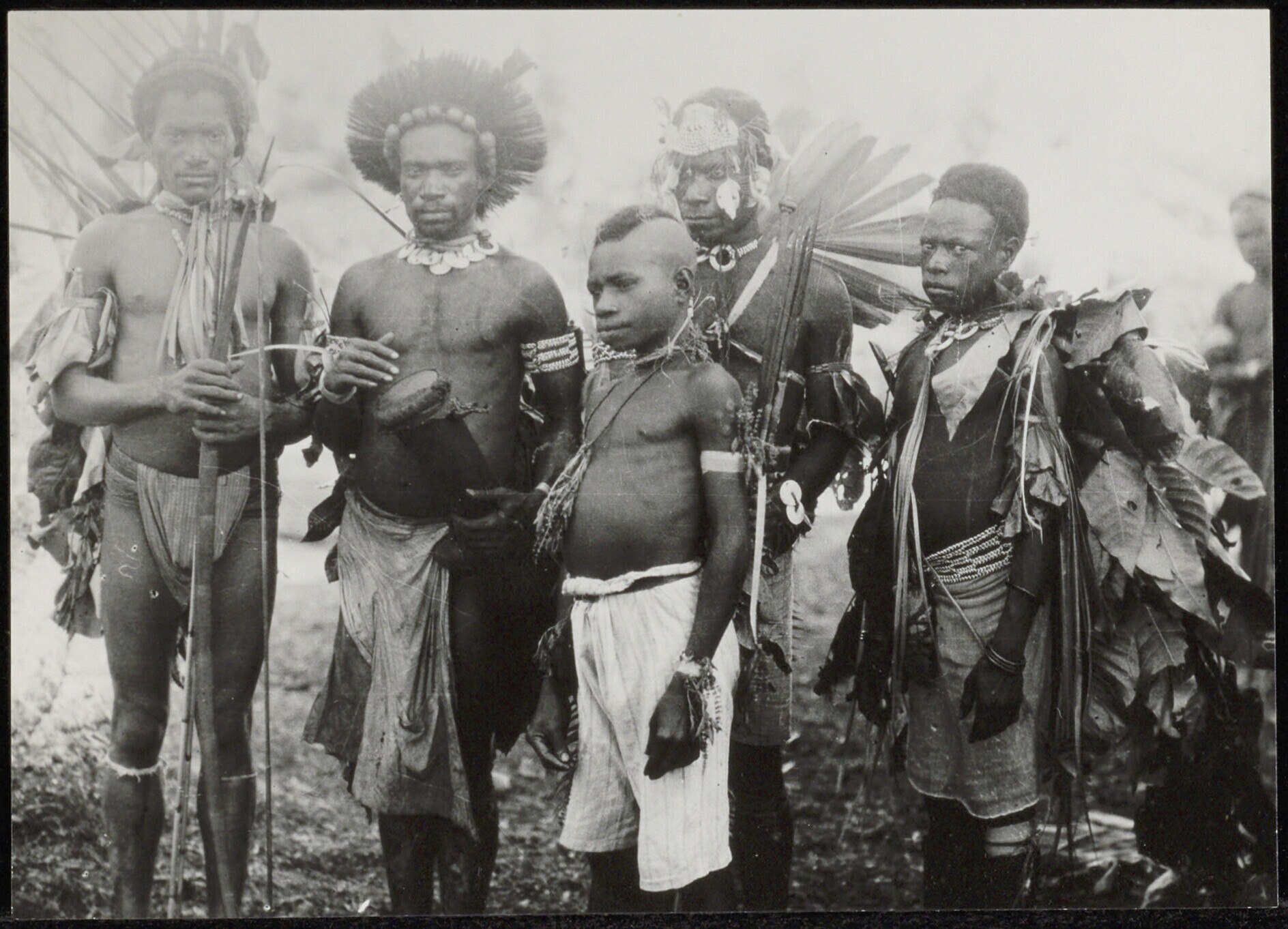 Mannen en een jongen in traditionele feesttooi mogelijk ter gelegenheid van een initiatiefeest