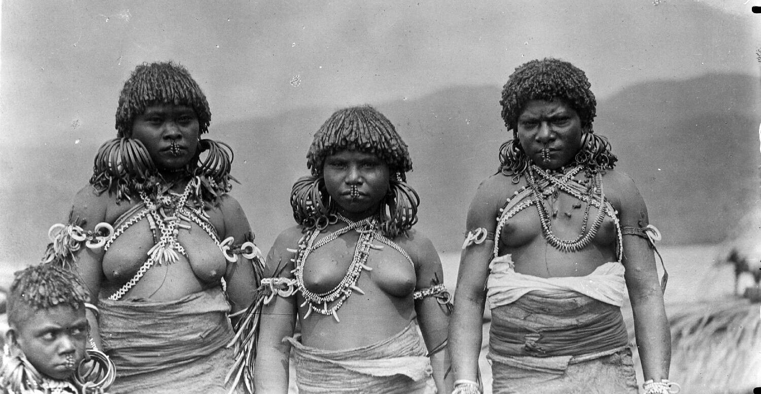 Portrait of three Papuan women (and a child) of the Sentani Lake region with arm, ear, nose, neck and breast ornaments
